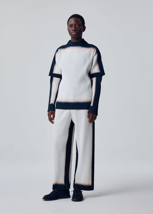 A model wears the HOMME PLISSÉ ISSEY MIYAKE FRAMEWORK : CHUSEN trousers.