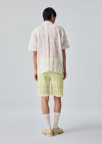 A model wears the HOMME PLISSÉ ISSEY MIYAKE LACE GRID PLEATS lace-grid-pleats-shirt-black.