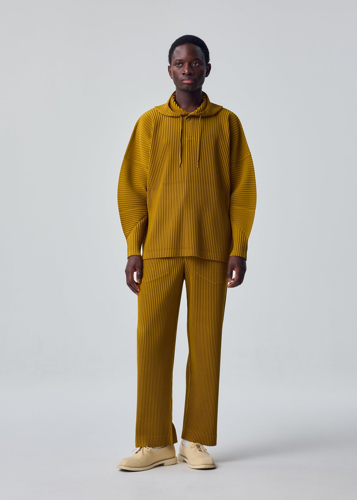 A model wears the HOMME PLISSÉ ISSEY MIYAKE MONTHLY COLORS : OCTOBER shirt.