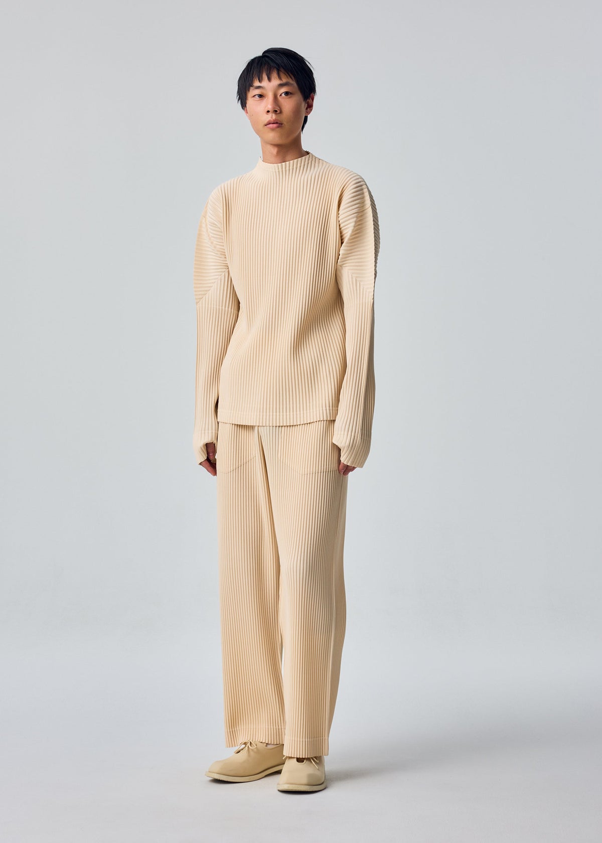 A model wears the HOMME PLISSÉ ISSEY MIYAKE MONTHLY COLORS : OCTOBER shirt.