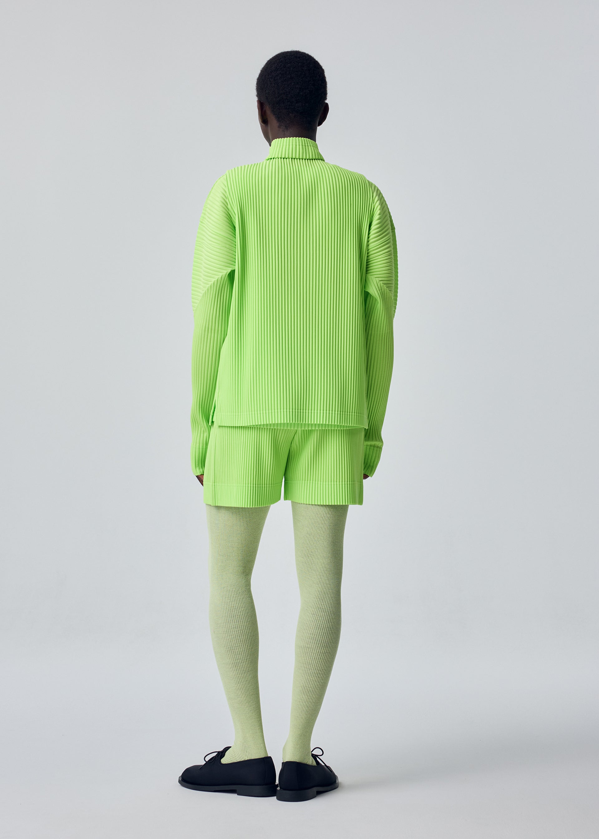 A model wears the HOMME PLISSÉ ISSEY MIYAKE COLOR PLEATS 1 color-pleats-1-t-shirt-ray-yellow.