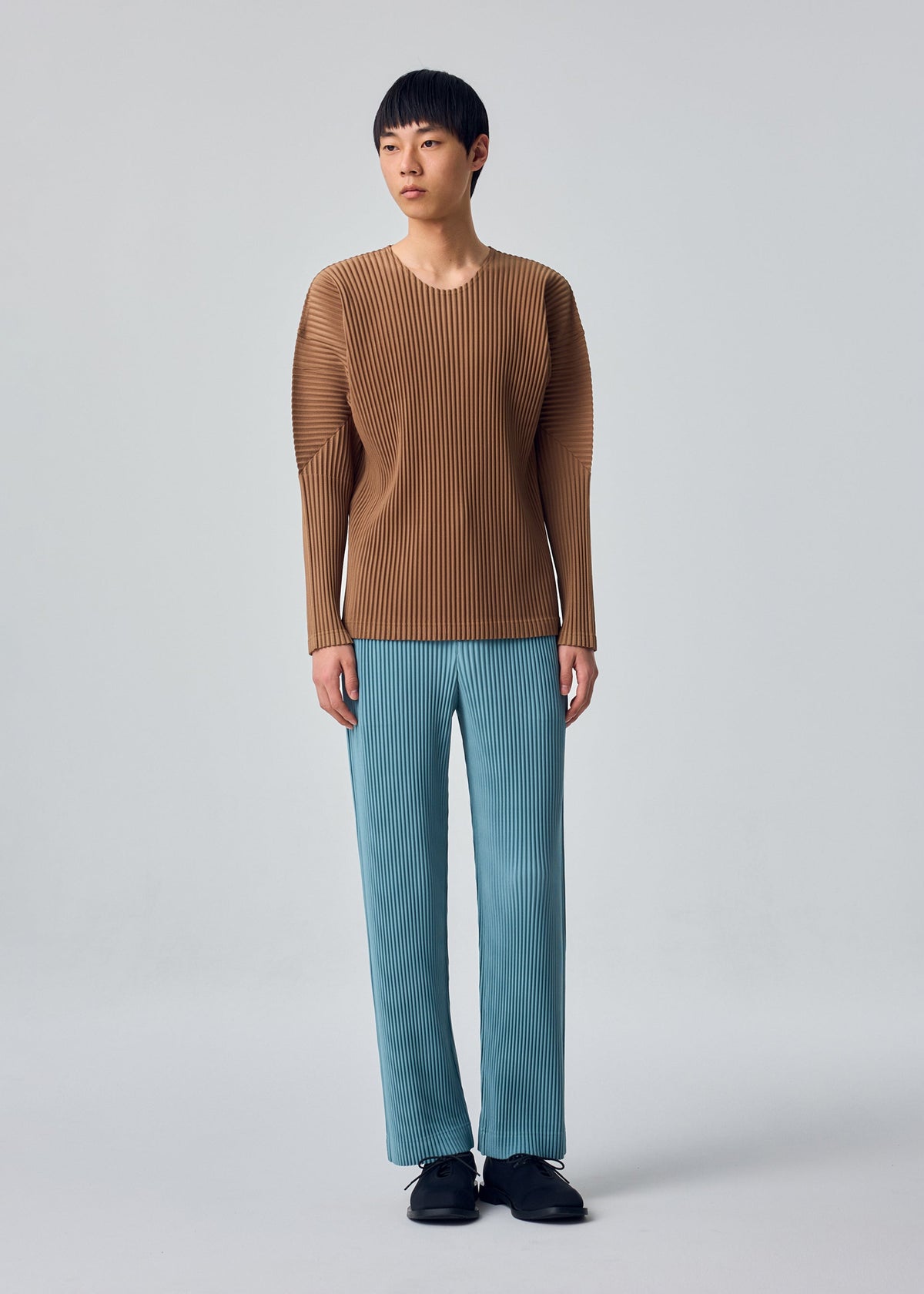 A model wears the HOMME PLISSÉ ISSEY MIYAKE COLOR PLEATS 2 t-shirt.