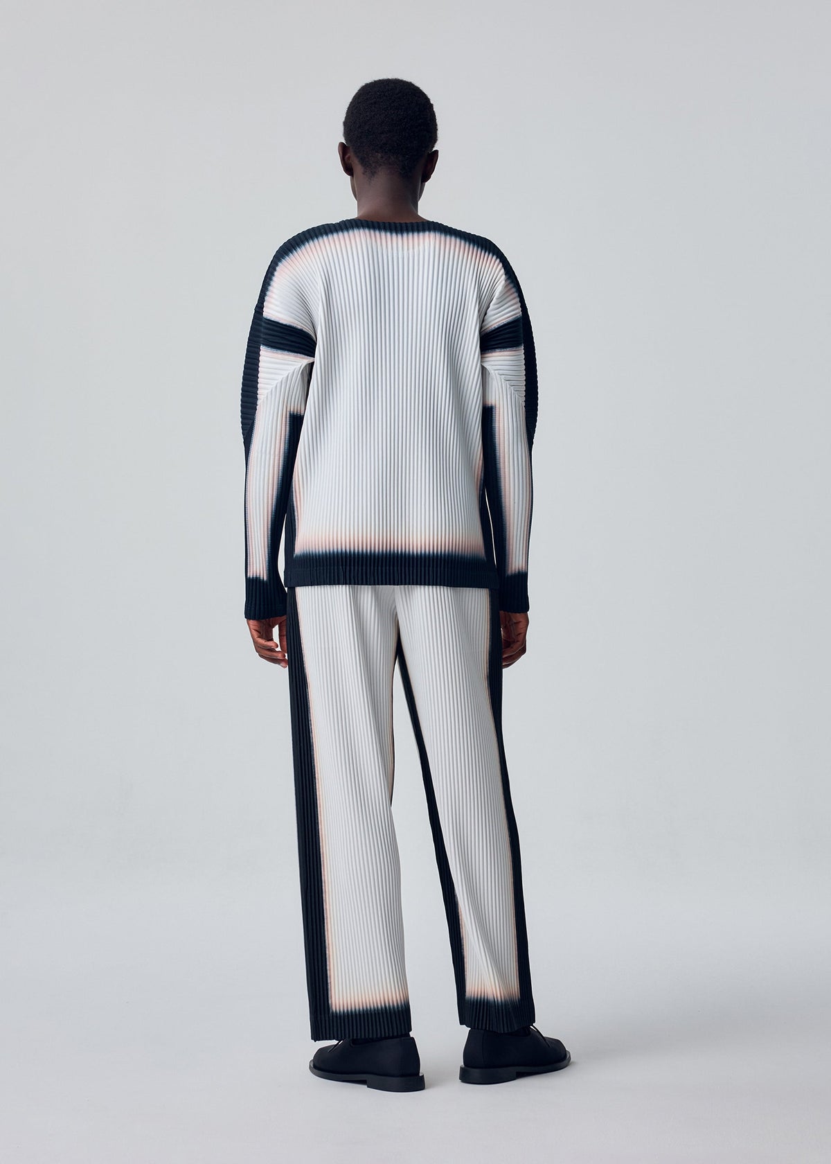 A model wears the HOMME PLISSÉ ISSEY MIYAKE FRAMEWORK : CHUSEN shirt.
