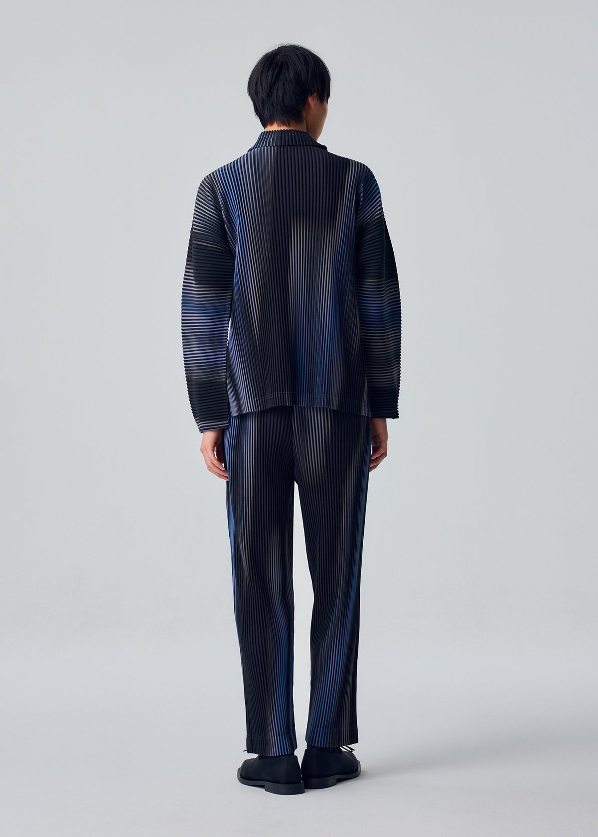 A model wears the HOMME PLISSÉ ISSEY MIYAKE BLEND OF LIGHTS blend-of-lights-t-shirt-brown.