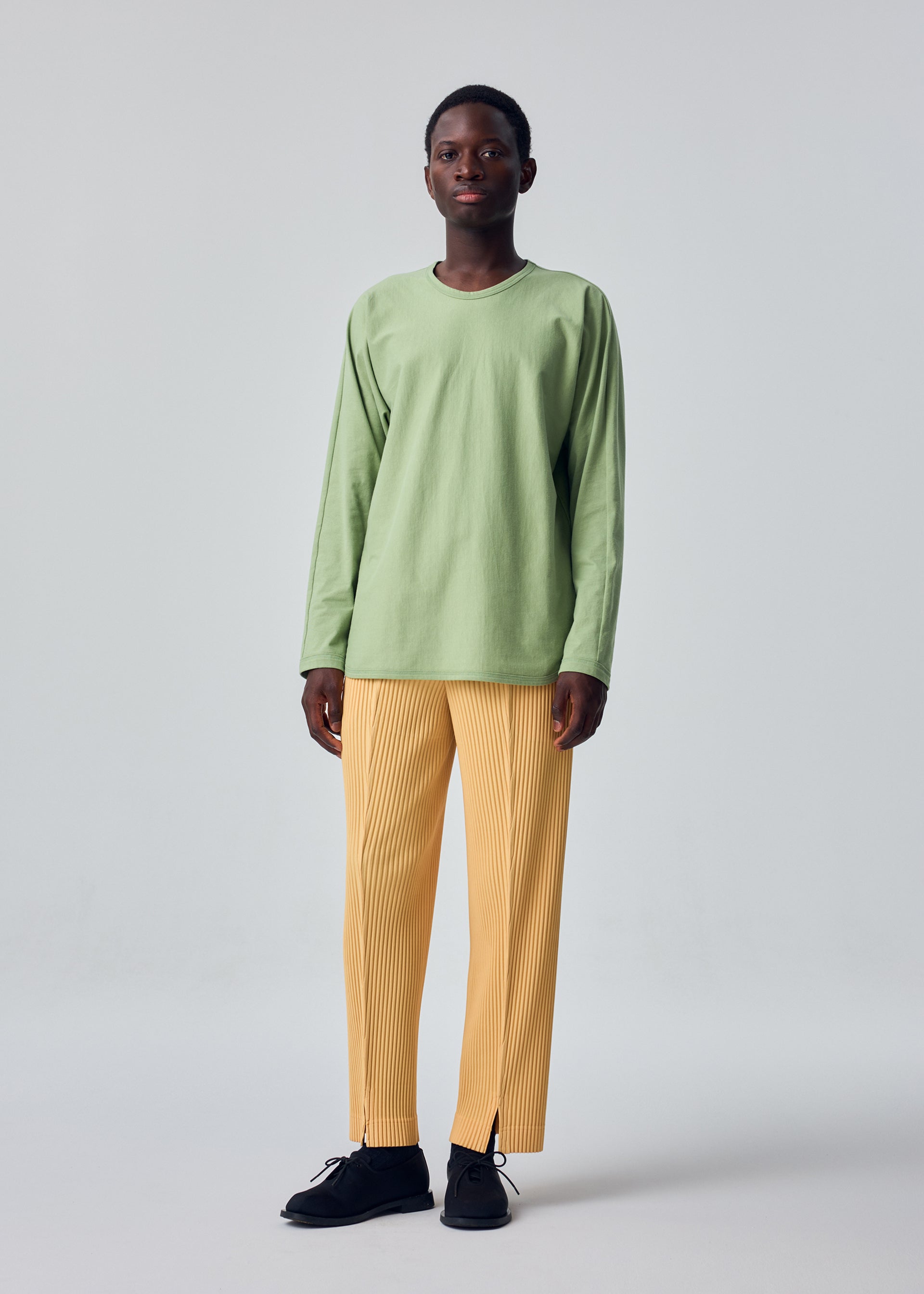 A model wears the HOMME PLISSÉ ISSEY MIYAKE RELEASE-T 1 release-t-1-t-shirt-brown.