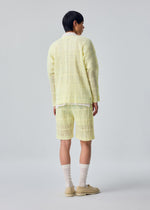 A model wears the HOMME PLISSÉ ISSEY MIYAKE LACE GRID PLEATS lace-grid-pleats-blouson-white.
