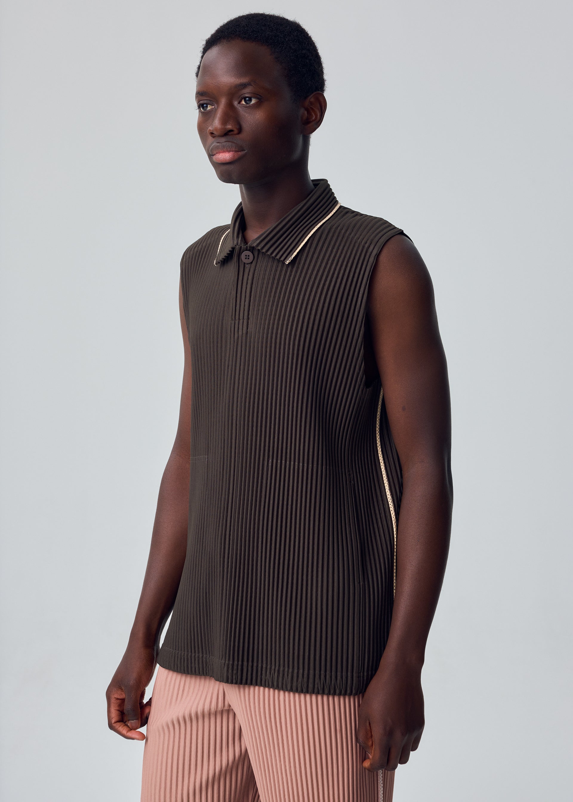 A model wears the HOMME PLISSÉ ISSEY MIYAKE EMBROIDERY STRIPES embroidery-stripes-vest-gloom-blue.