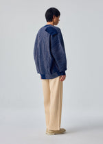 A model wears the HOMME PLISSÉ ISSEY MIYAKE IN THE SHADOW KNIT knit.
