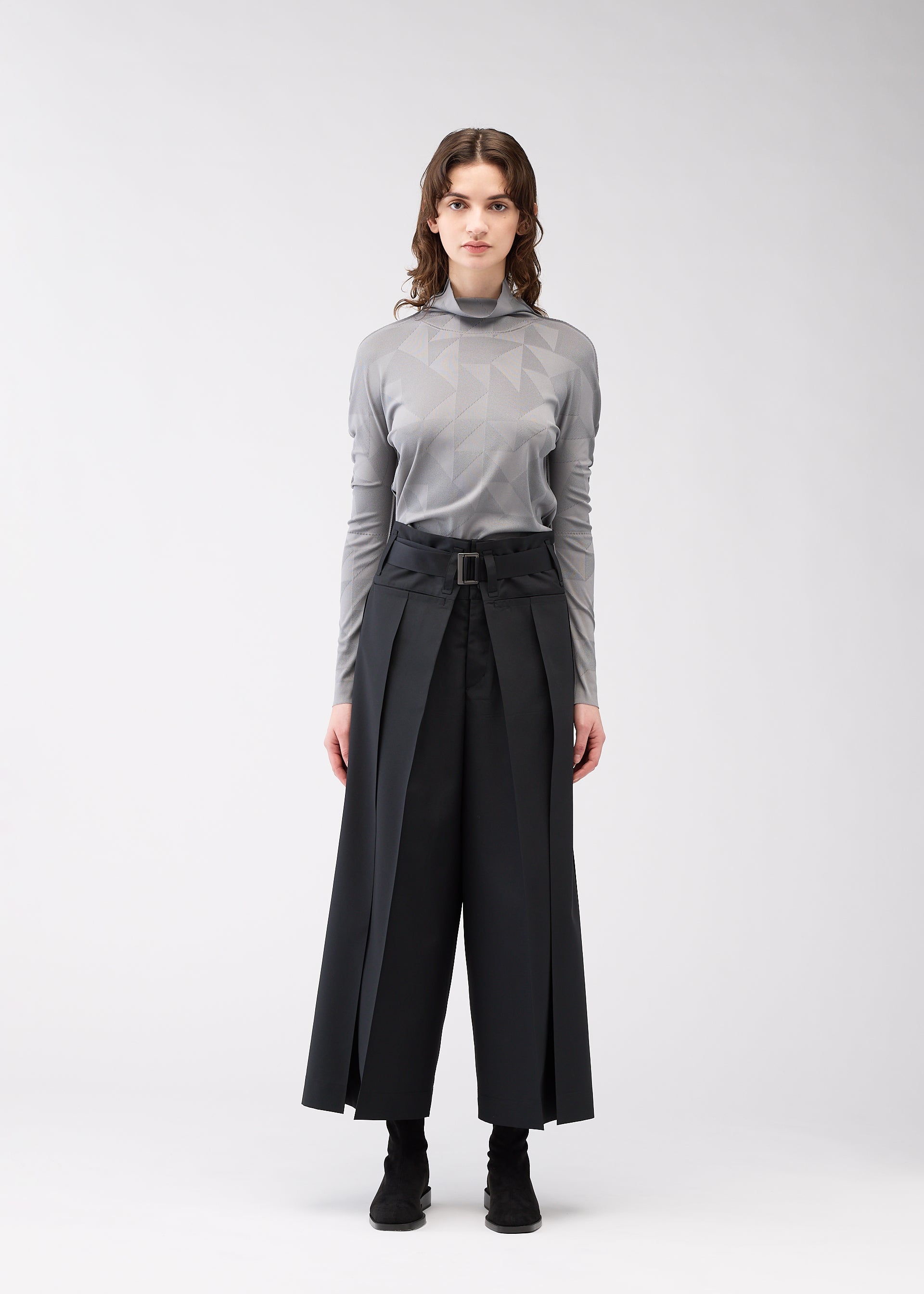 A model wears the 132 5. ISSEY MIYAKE FLAT SIDE FOLD trousers.