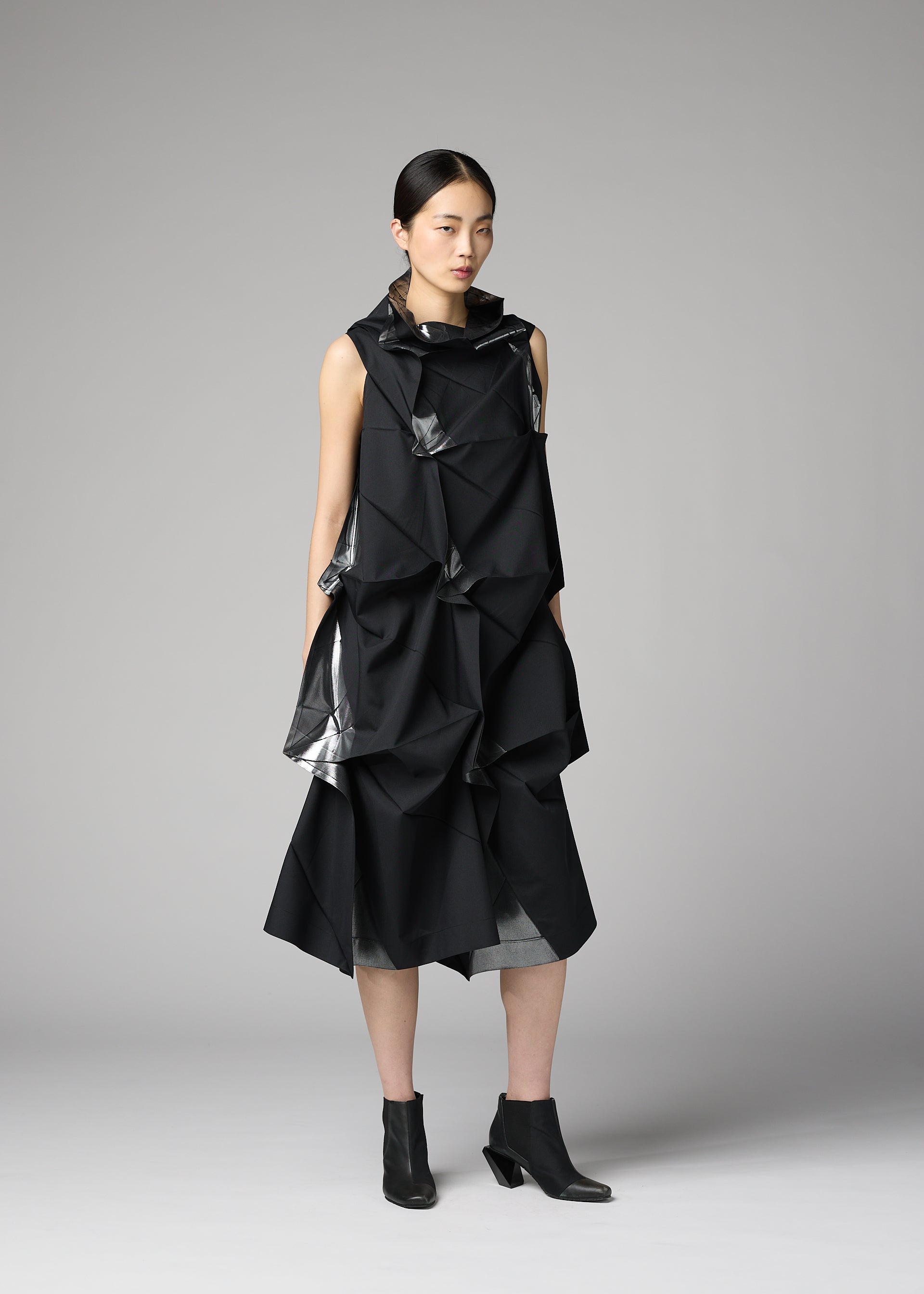 A model wears the 132 5. ISSEY MIYAKE No.1-1 no-10-ramie-dress-black-x-silver.