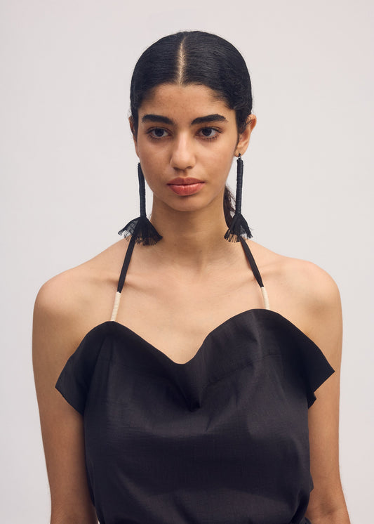 A model wears the ISSEY MIYAKE CLOTH AND CORD ACC jewellery.