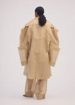 A model wears the ISSEY MIYAKE PRESS AND PRESSED coat.