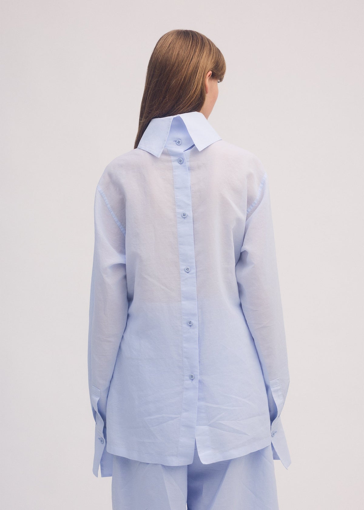 A model wears the ISSEY MIYAKE PAPER ESQUE U shirt.