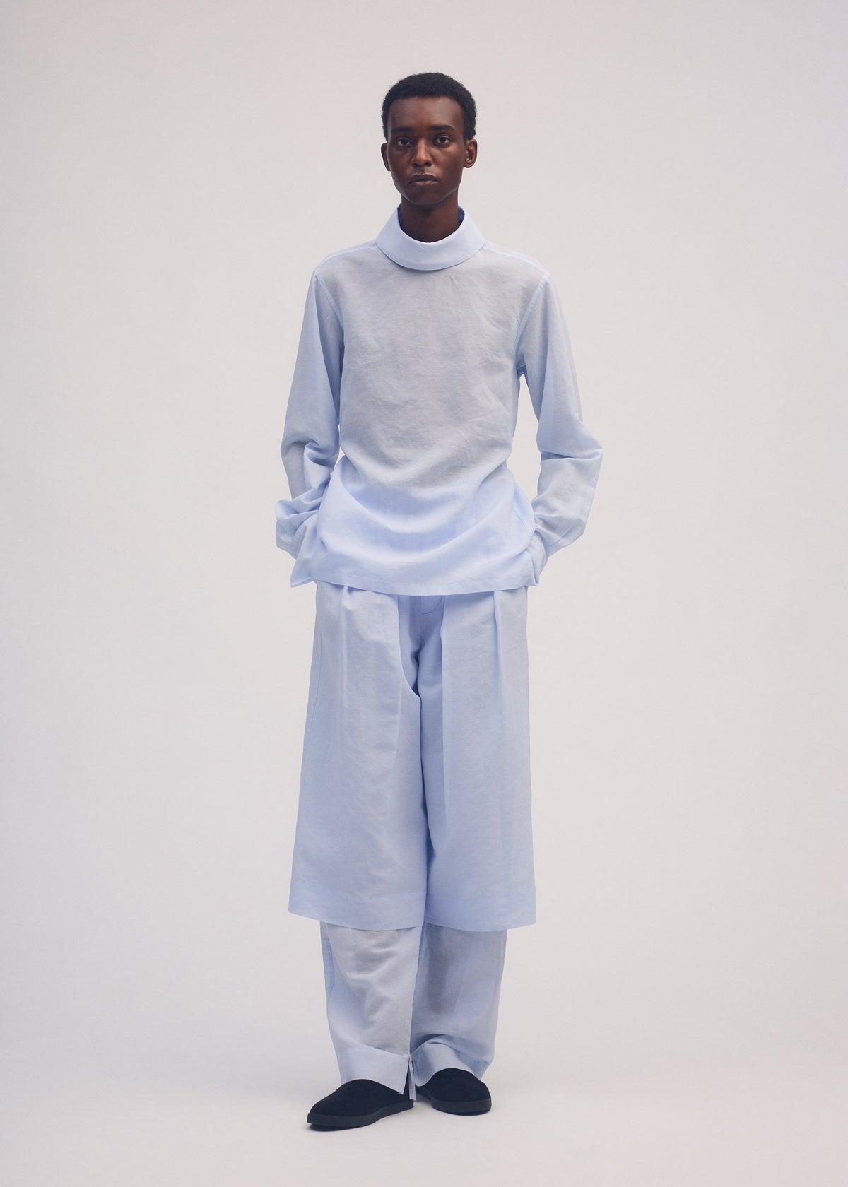 A model wears the ISSEY MIYAKE PAPER ESQUE U shirt.