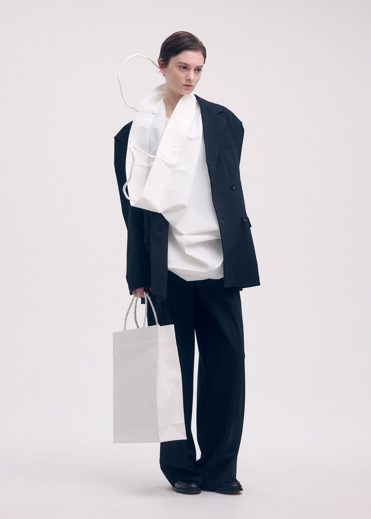A model wears the ISSEY MIYAKE THIS IS A PAPER BAG bag.