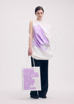 A model wears the ISSEY MIYAKE THIS IS A PAPER BAG (POSTER) bag.