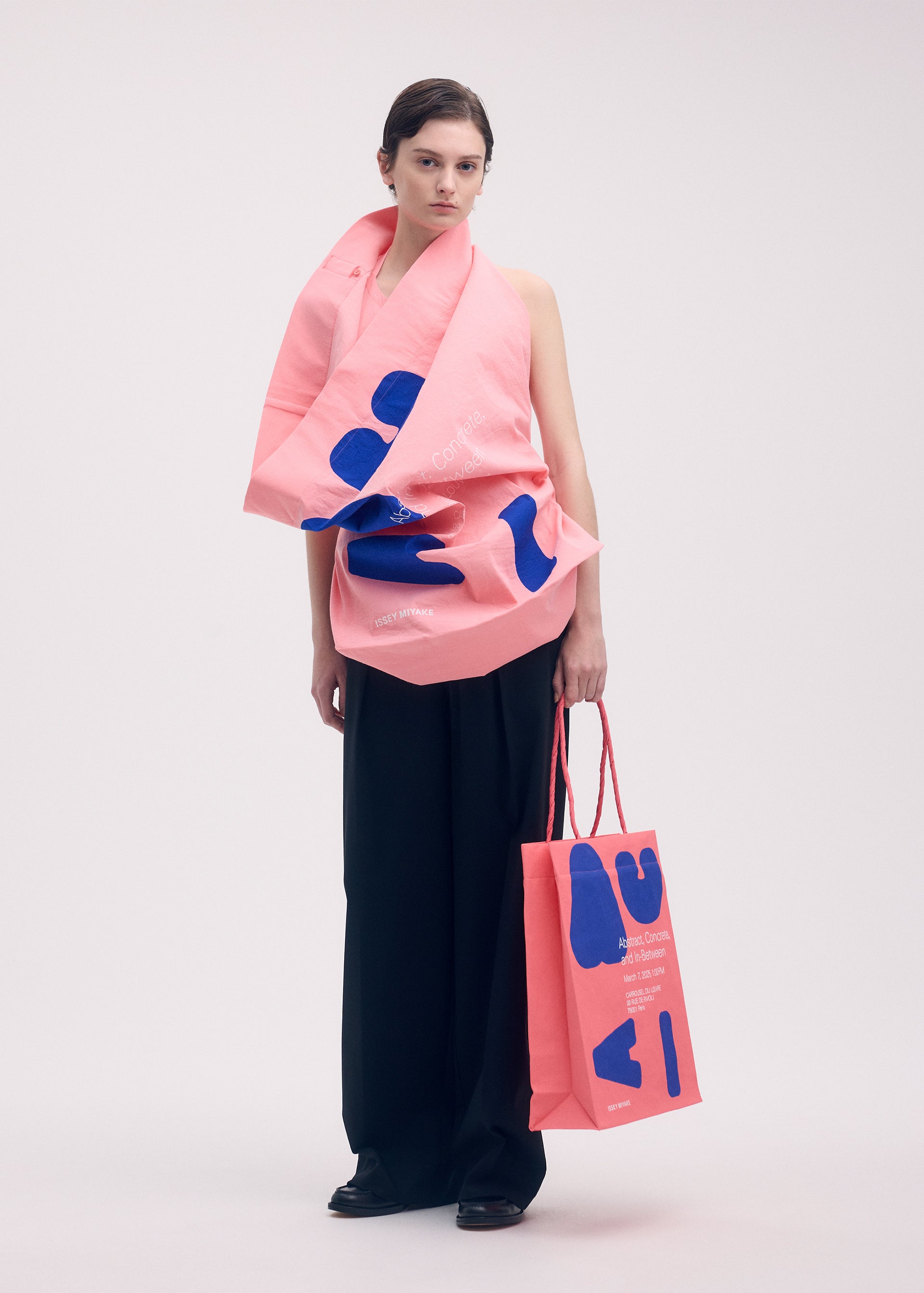 A model wears the ISSEY MIYAKE THIS IS A PAPER BAG (POSTER) bag.