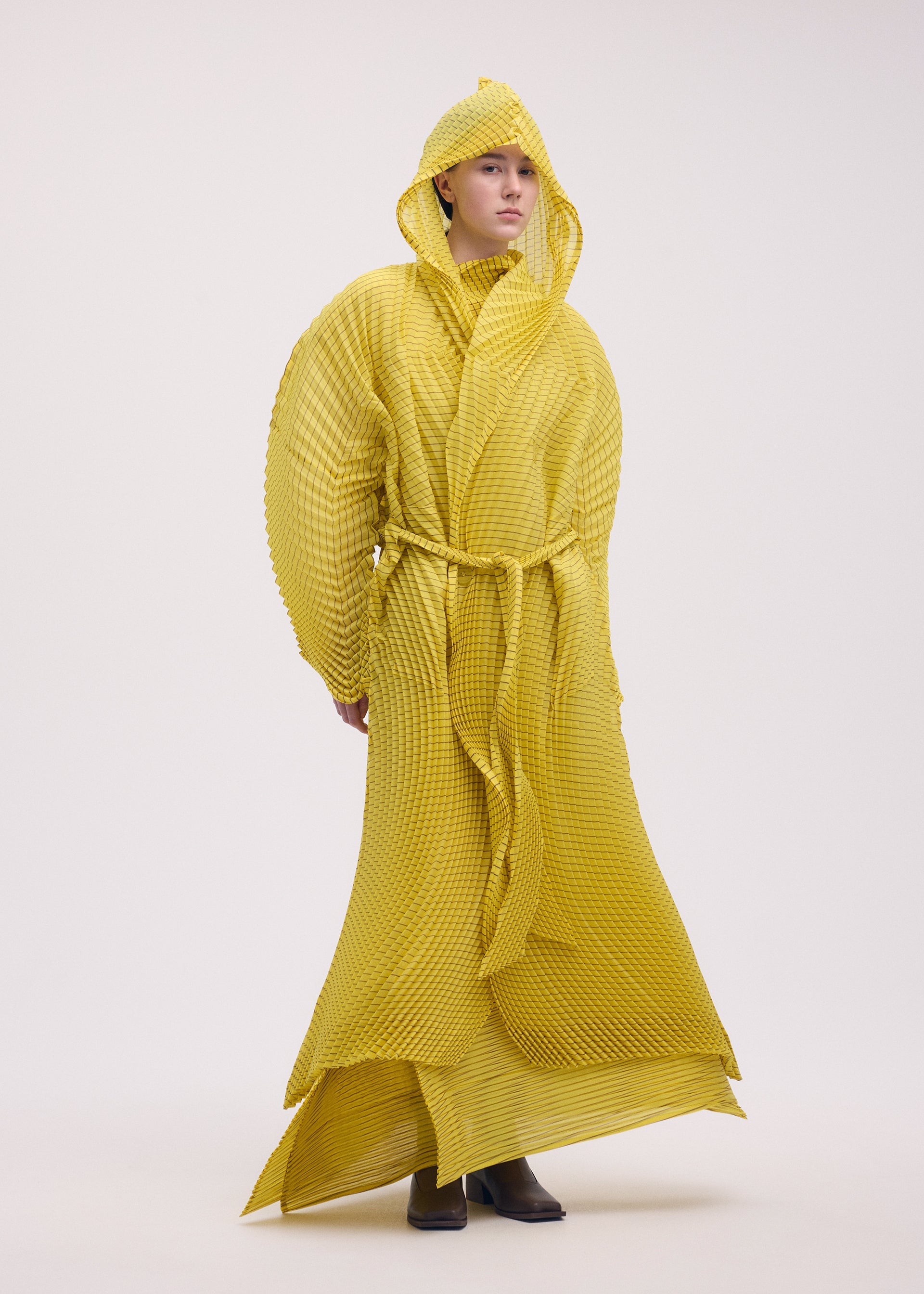 A model wears the Issey Miyake GENERIC STRIPES HAND PLEATS coat.