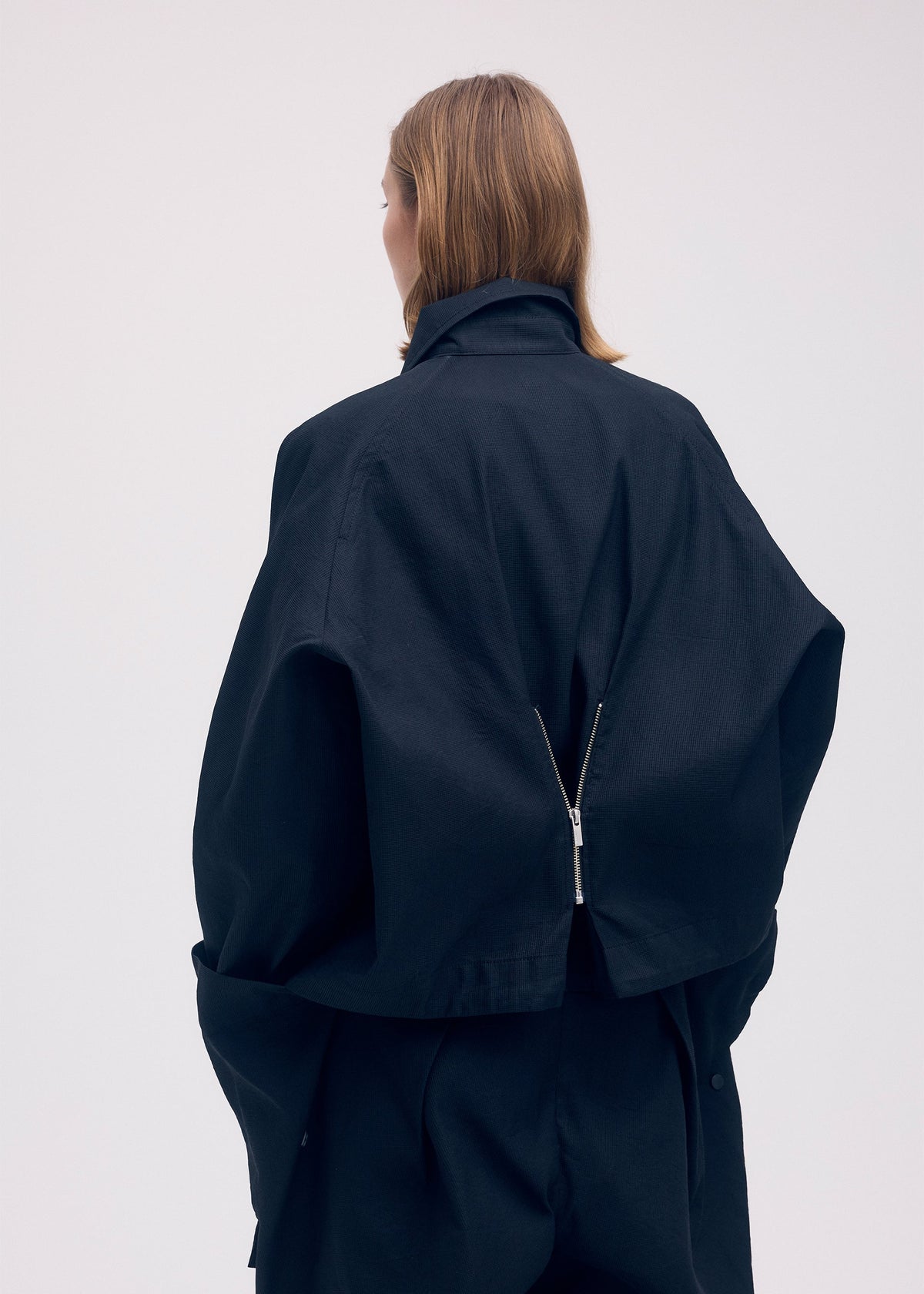 A model wears the Issey Miyake PEEKABOO jacket.