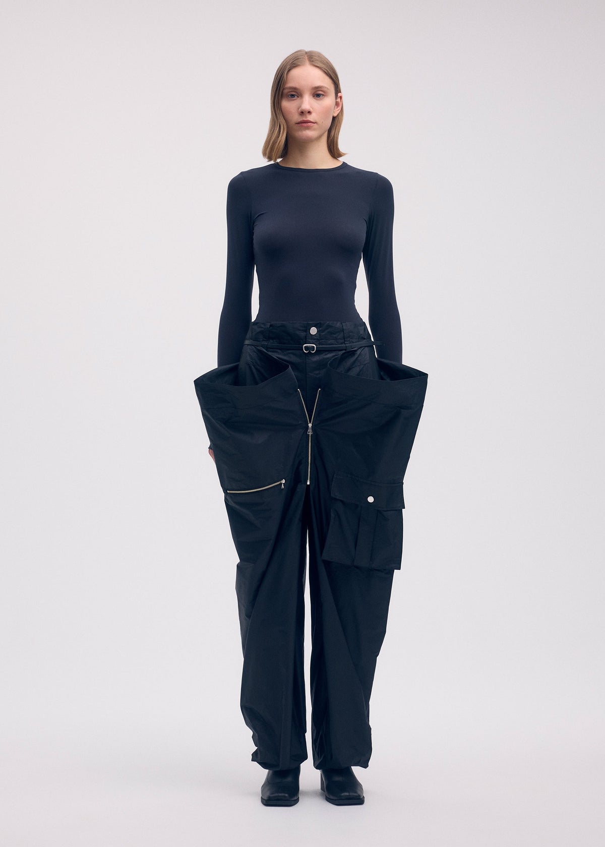 A model wears the Issey Miyake AERIAL STEEL trousers.