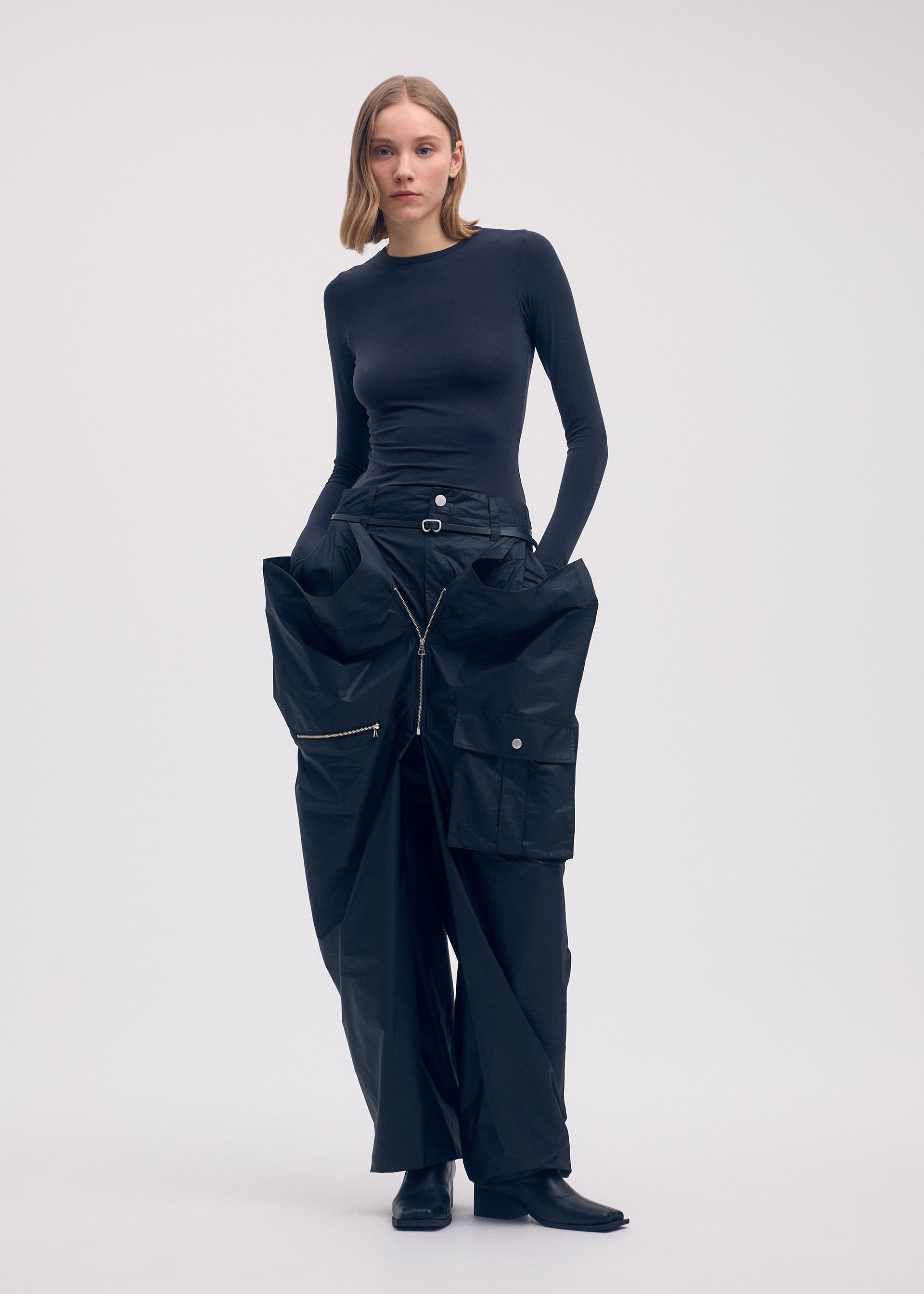 A model wears the Issey Miyake AERIAL STEEL trousers.