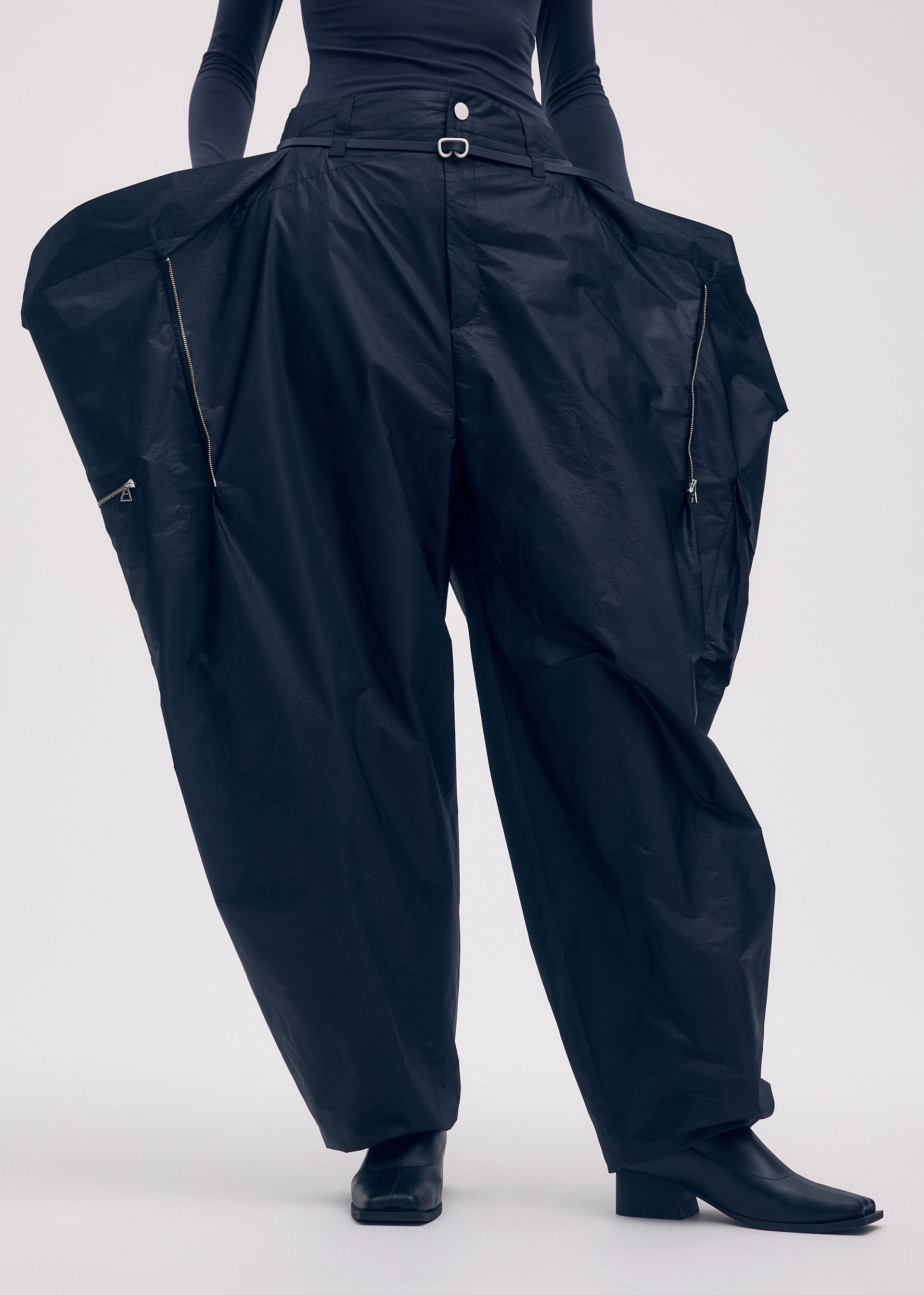 A model wears the Issey Miyake AERIAL STEEL trousers.