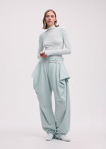 A model wears the Issey Miyake WOOL TWEED PANTS trousers.