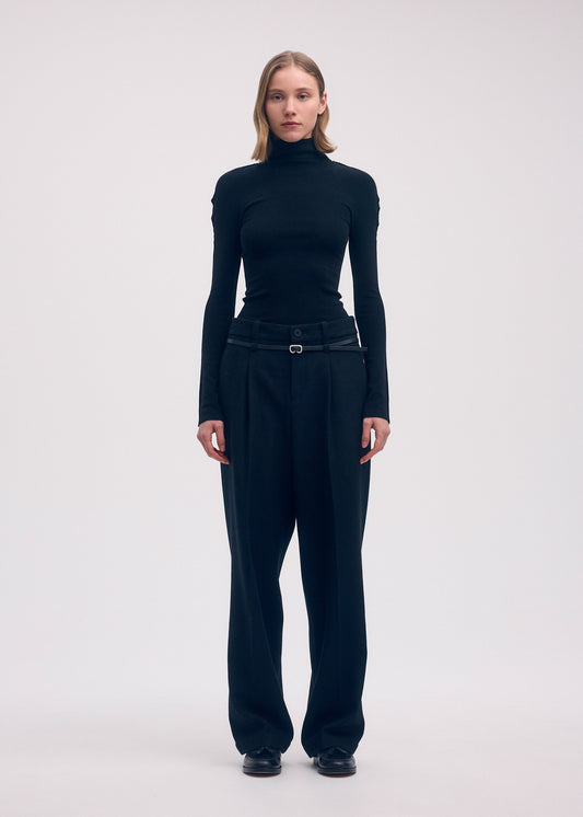 A model wears the Issey Miyake WOOL TWEED PANTS trousers.