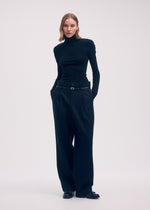 A model wears the Issey Miyake WOOL TWEED PANTS trousers.