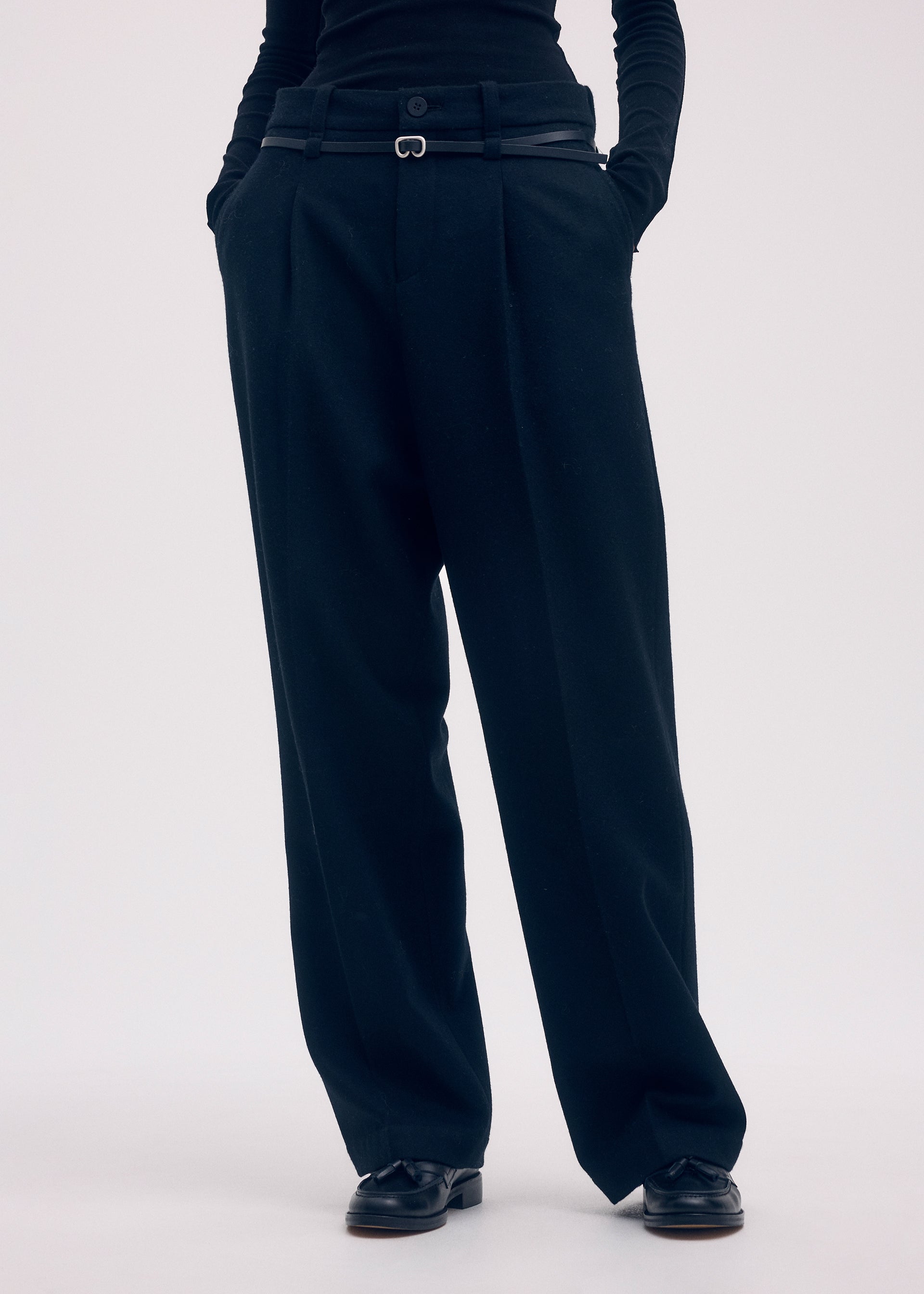 A model wears the Issey Miyake WOOL TWEED PANTS trousers.