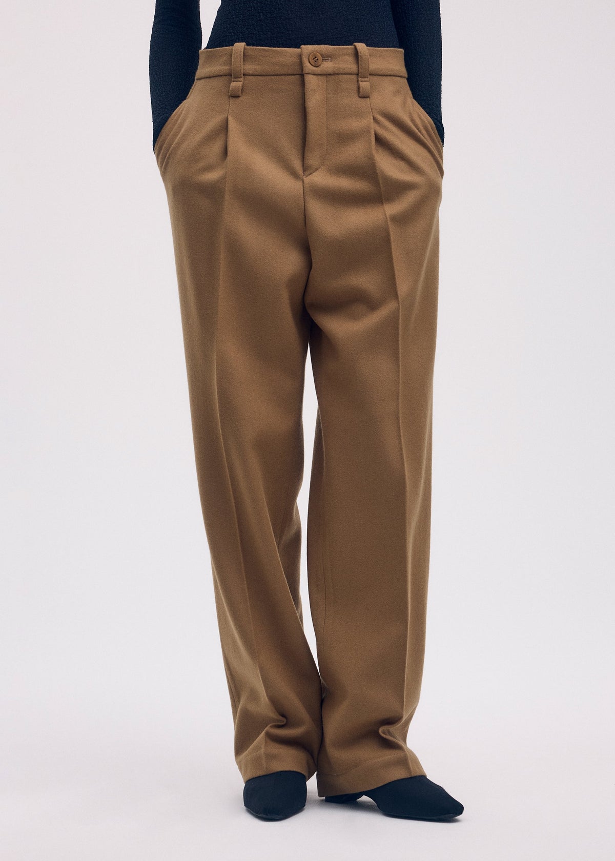 A model wears the Issey Miyake WOOL TWEED PANTS trousers.