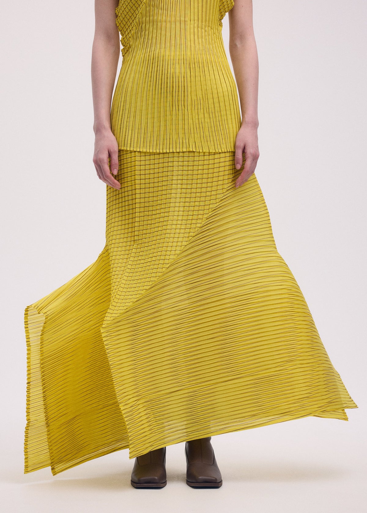 A model wears the Issey Miyake GENERIC STRIPES skirt.