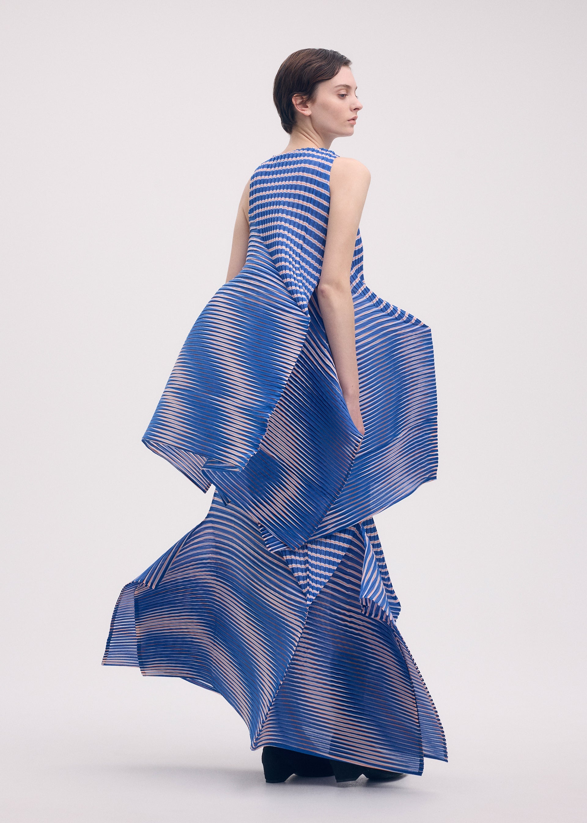 A model wears the Issey Miyake GENERIC STRIPES skirt.