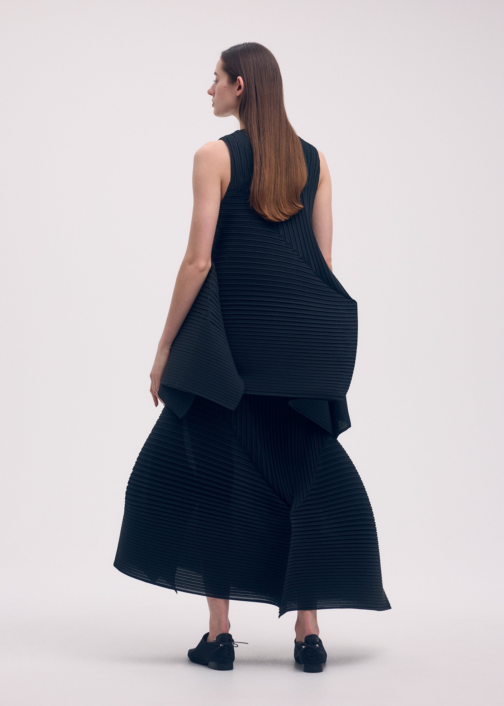 A model wears the ISSEY MIYAKE FOLD PLEATS skirt.