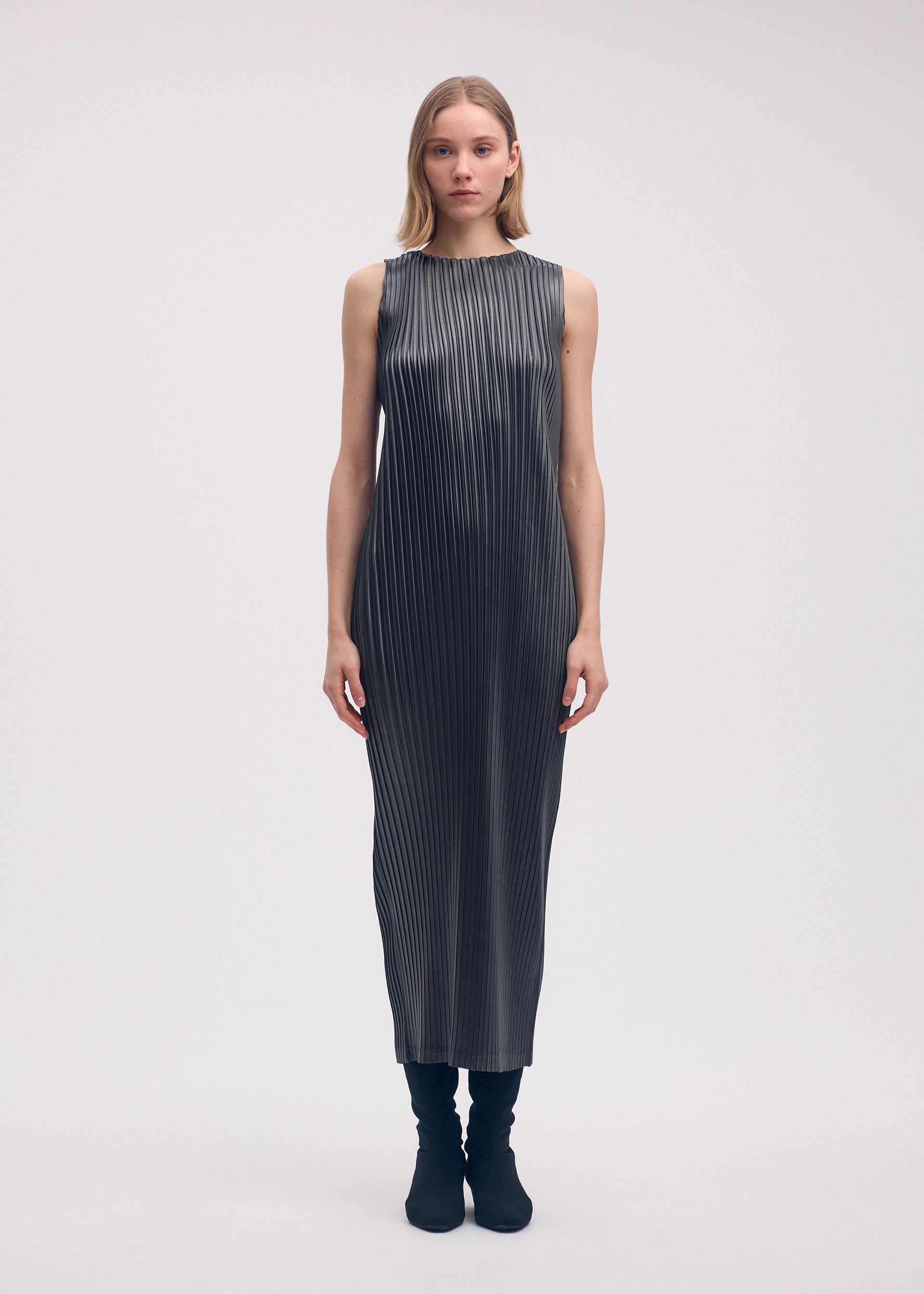 A model wears the Issey Miyake GLOSSED METAL PLEATS dress.