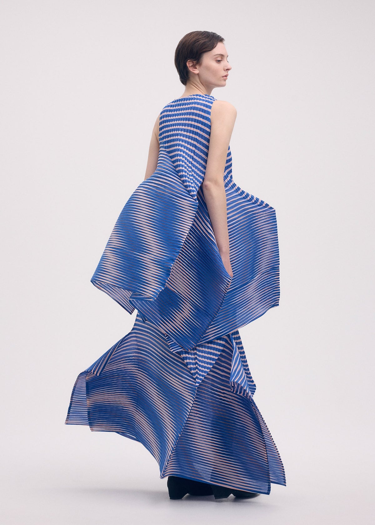 A model wears the Issey Miyake GENERIC STRIPES dress.