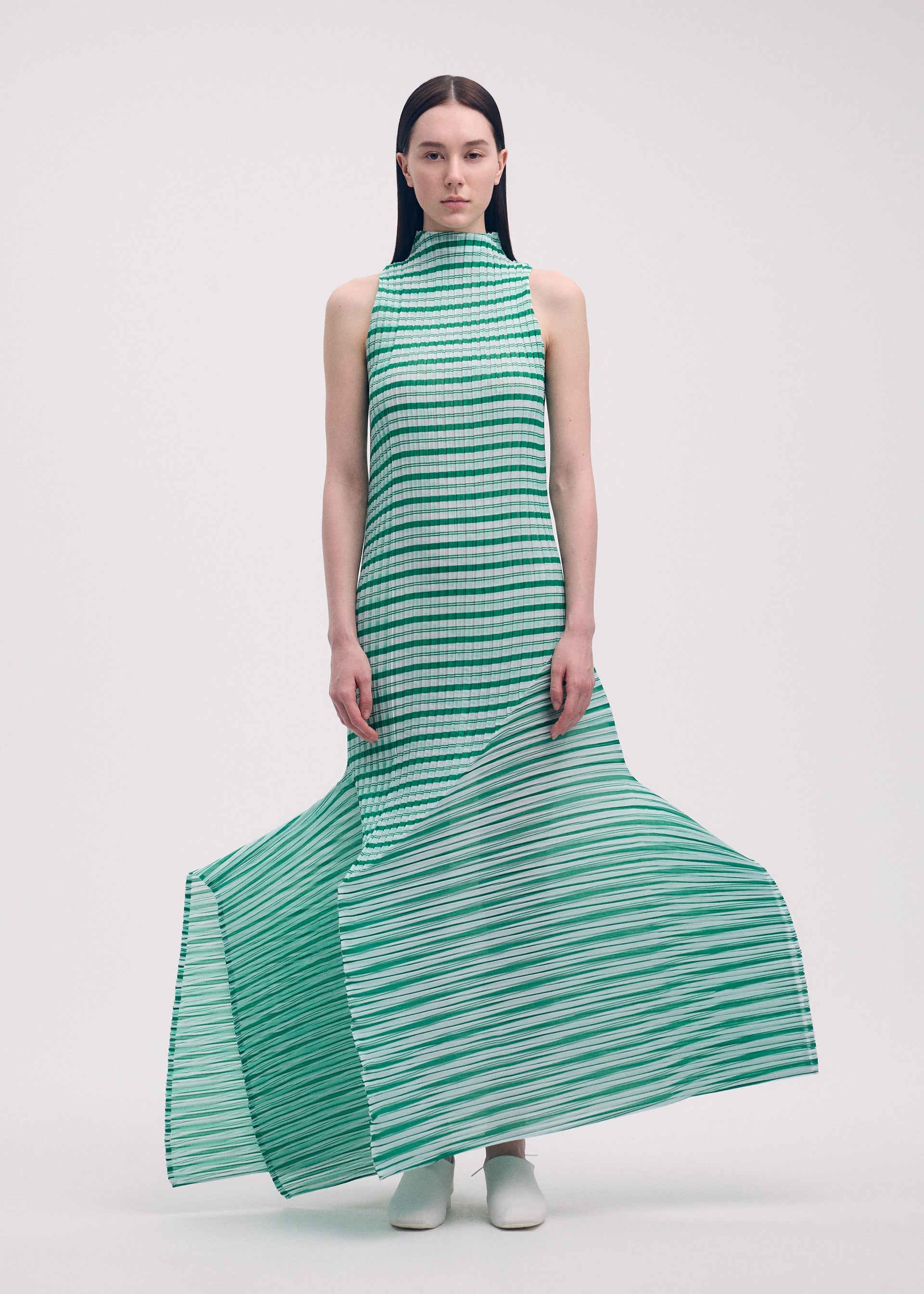 A model wears the Issey Miyake GENERIC STRIPES dress.