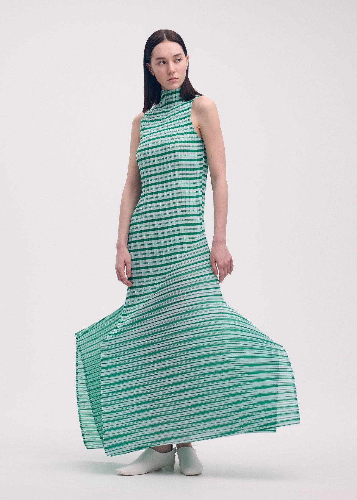 A model wears the Issey Miyake GENERIC STRIPES dress.