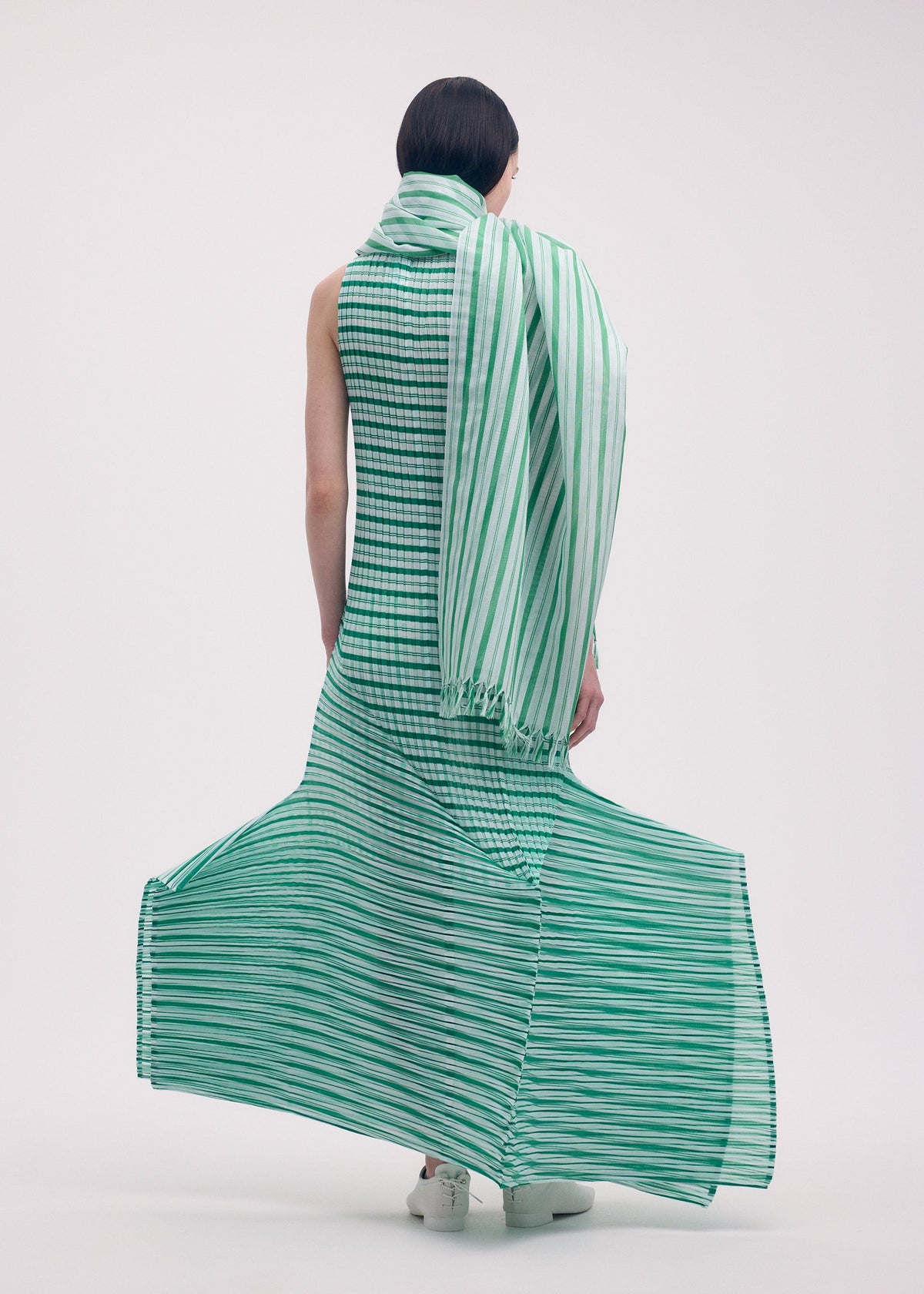 A model wears the Issey Miyake GENERIC STRIPES dress.