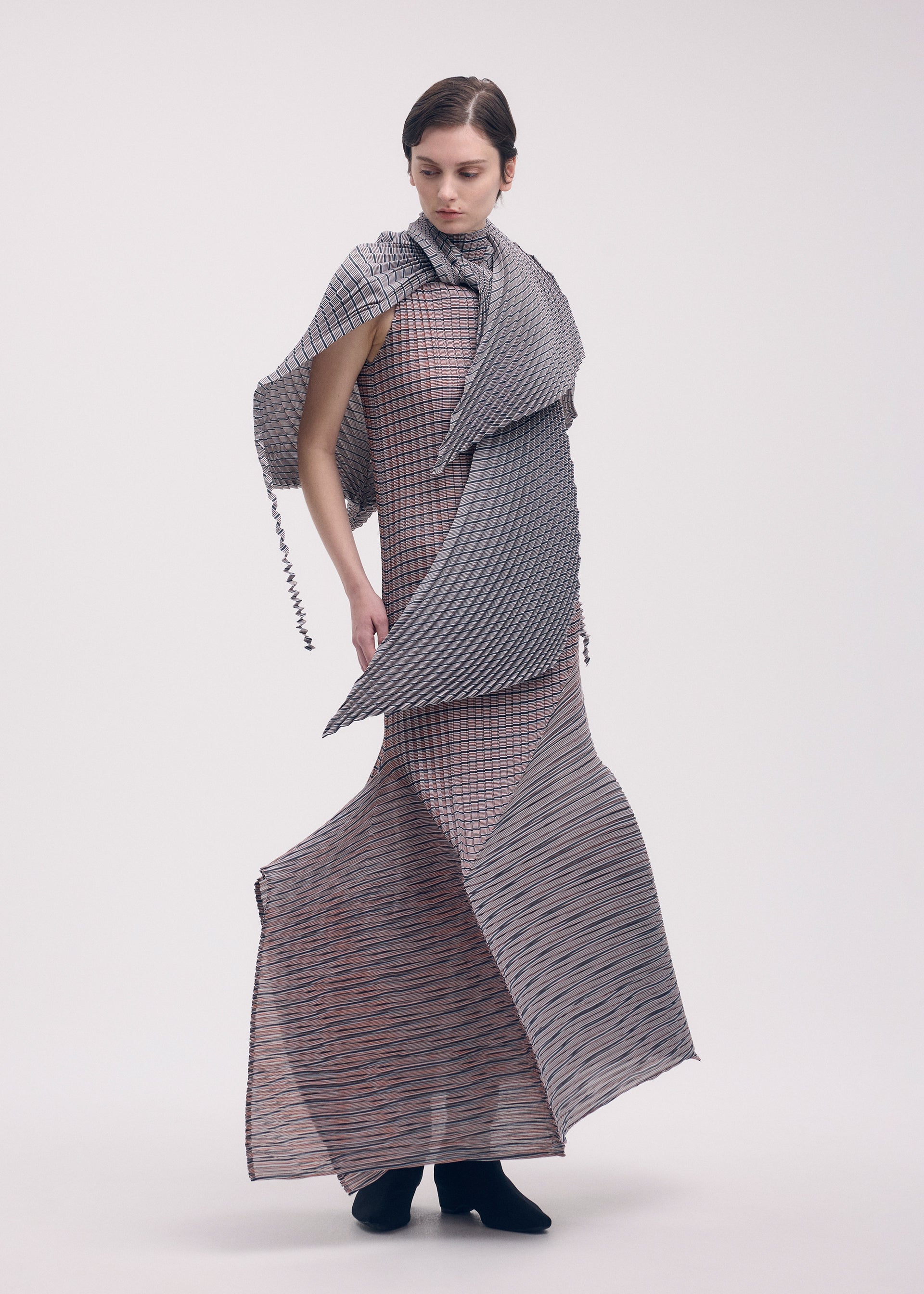 A model wears the Issey Miyake GENERIC STRIPES dress.