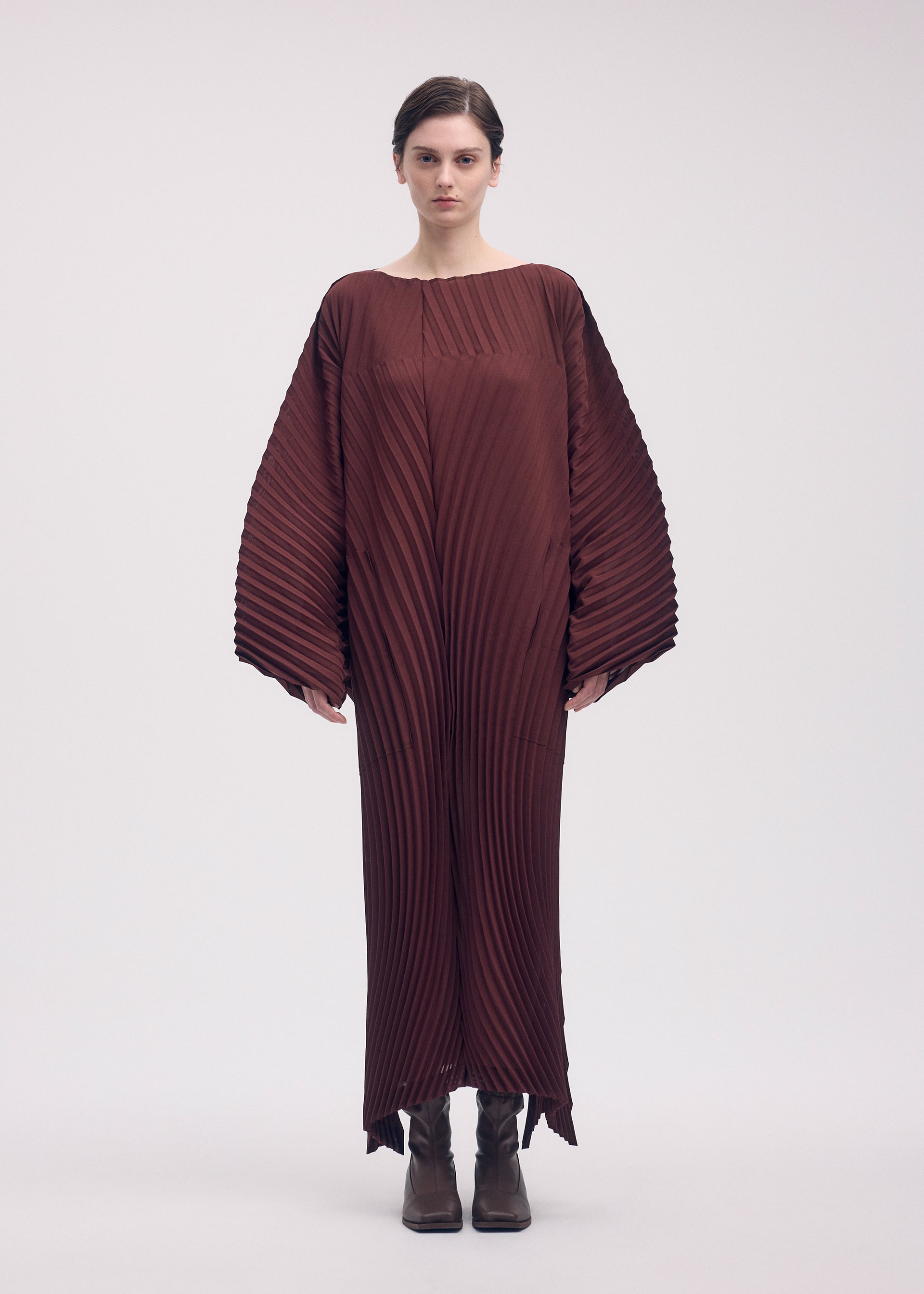 A model wears the ISSEY MIYAKE WAVE PLEATS dress.