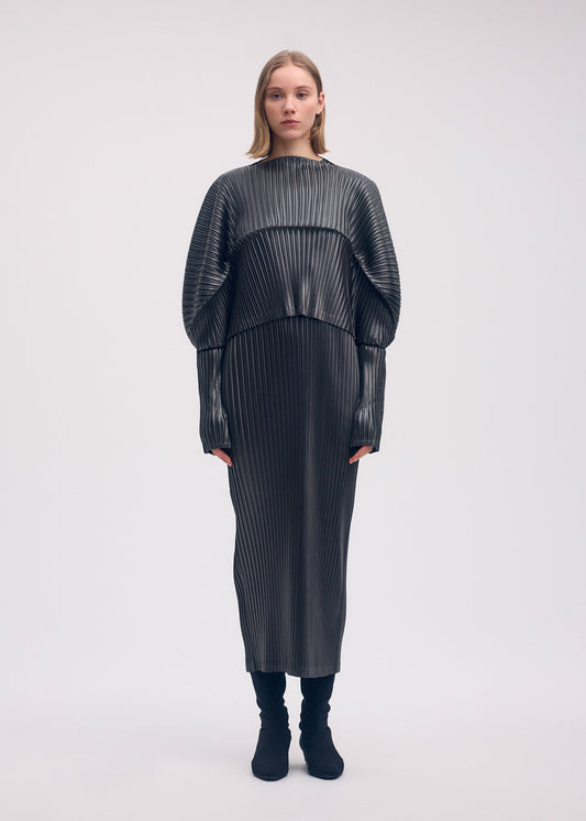 A model wears the Issey Miyake GLOSSED METAL PLEATS shirt.