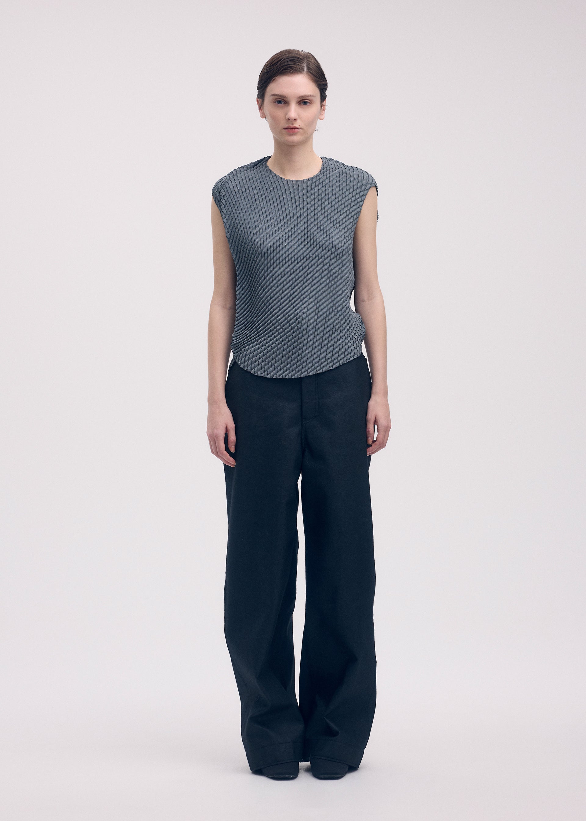 A model wears the Issey Miyake RESTORE BLEND PLEATS shirt.