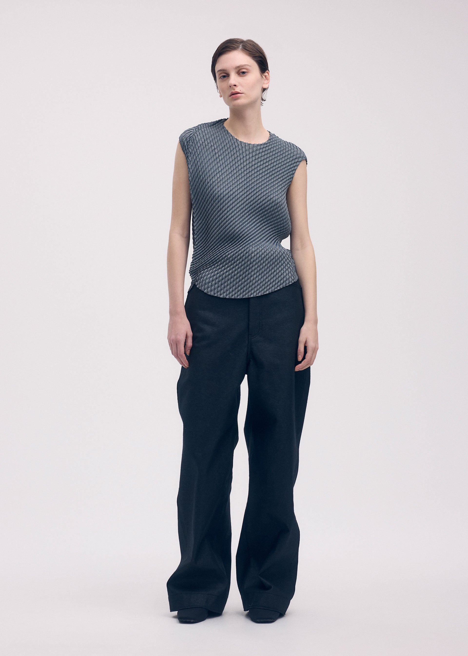 A model wears the Issey Miyake RESTORE BLEND PLEATS shirt.