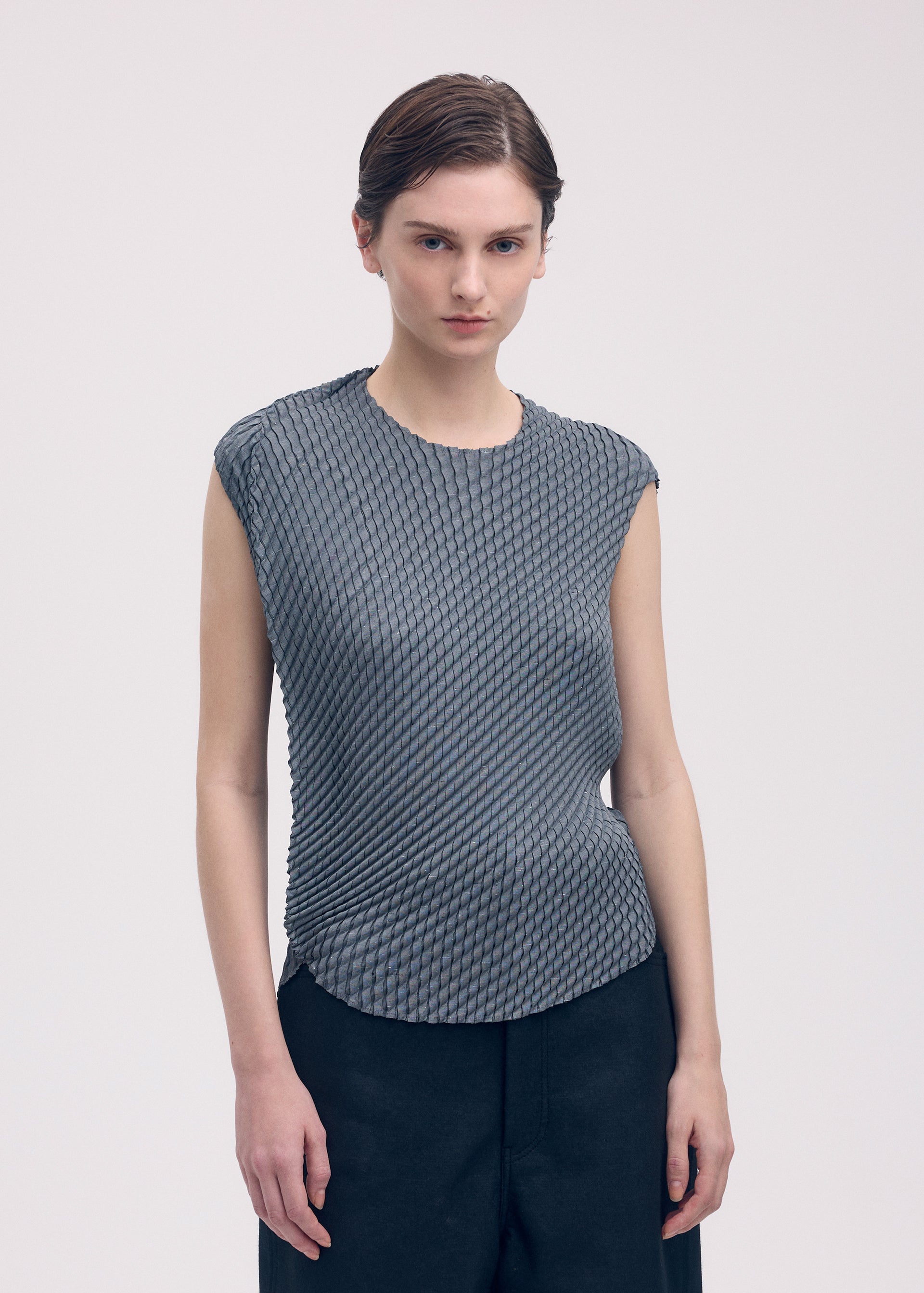 A model wears the Issey Miyake RESTORE BLEND PLEATS shirt.