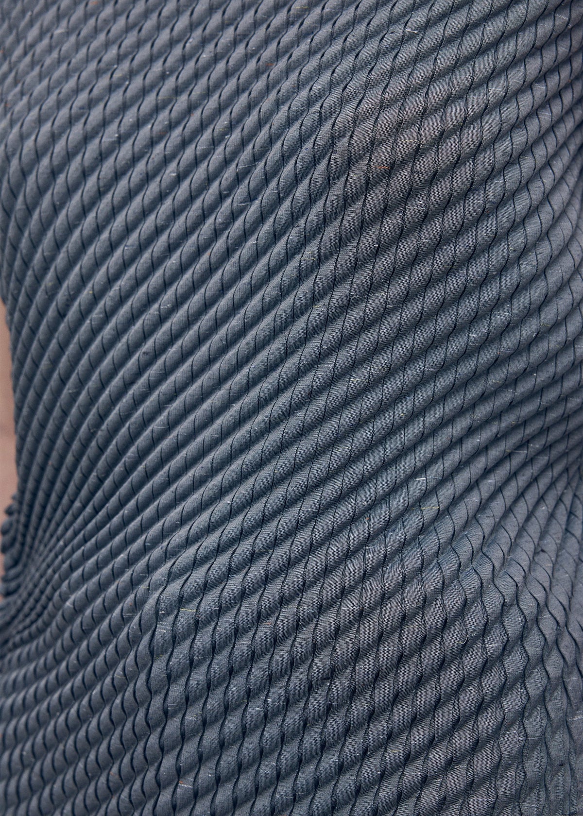 A model wears the Issey Miyake RESTORE BLEND PLEATS shirt.