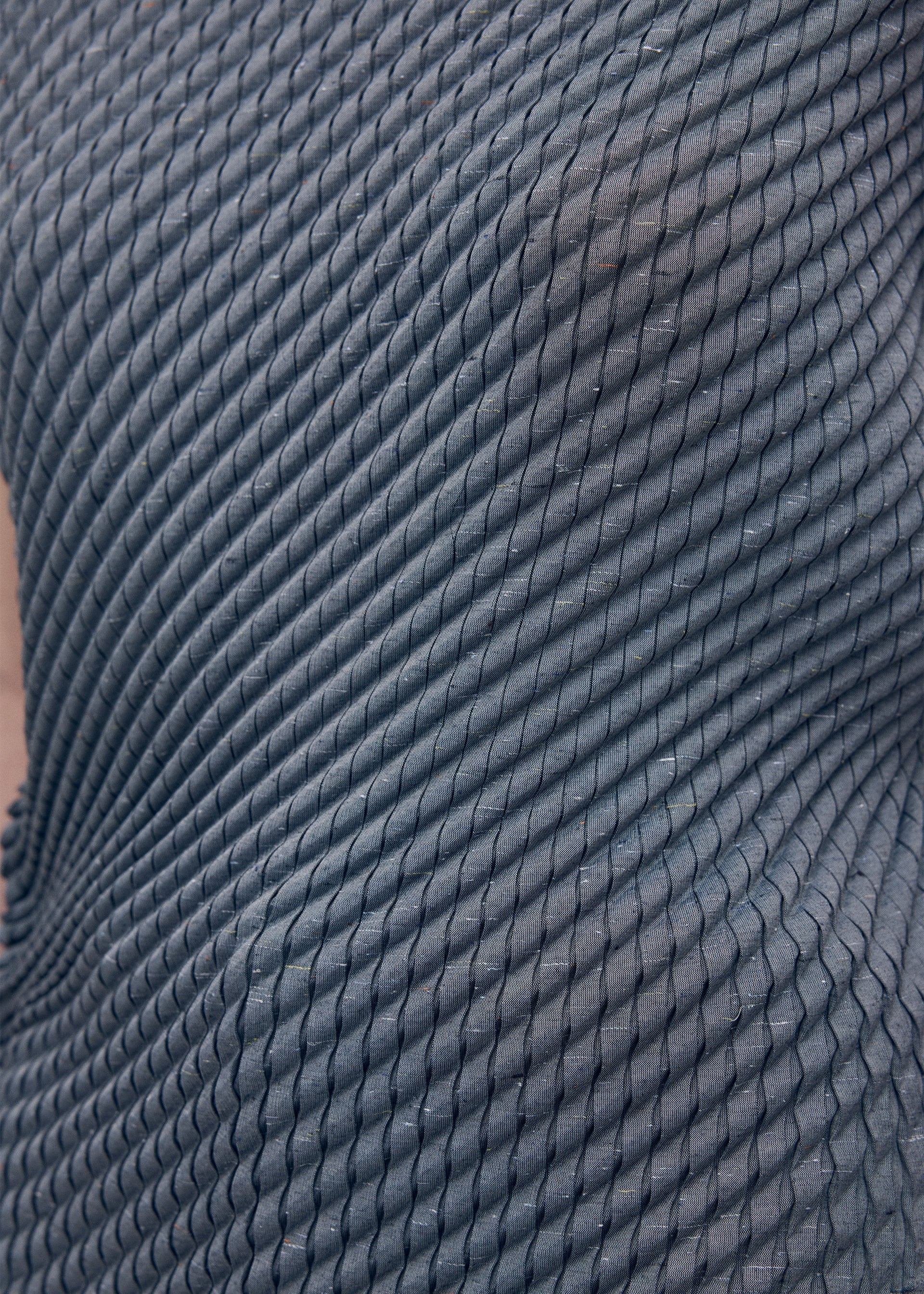 A model wears the Issey Miyake RESTORE BLEND PLEATS shirt.