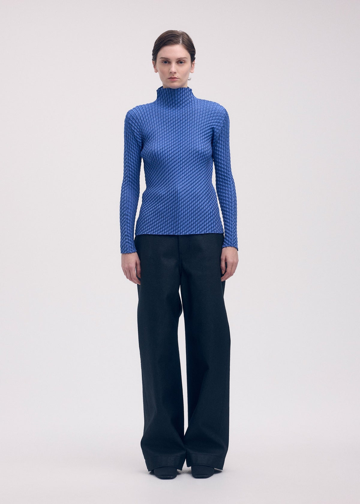 A model wears the Issey Miyake RESTORE BLEND PLEATS shirt.