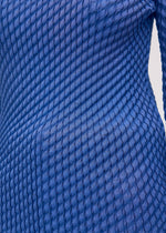 A model wears the Issey Miyake RESTORE BLEND PLEATS shirt.