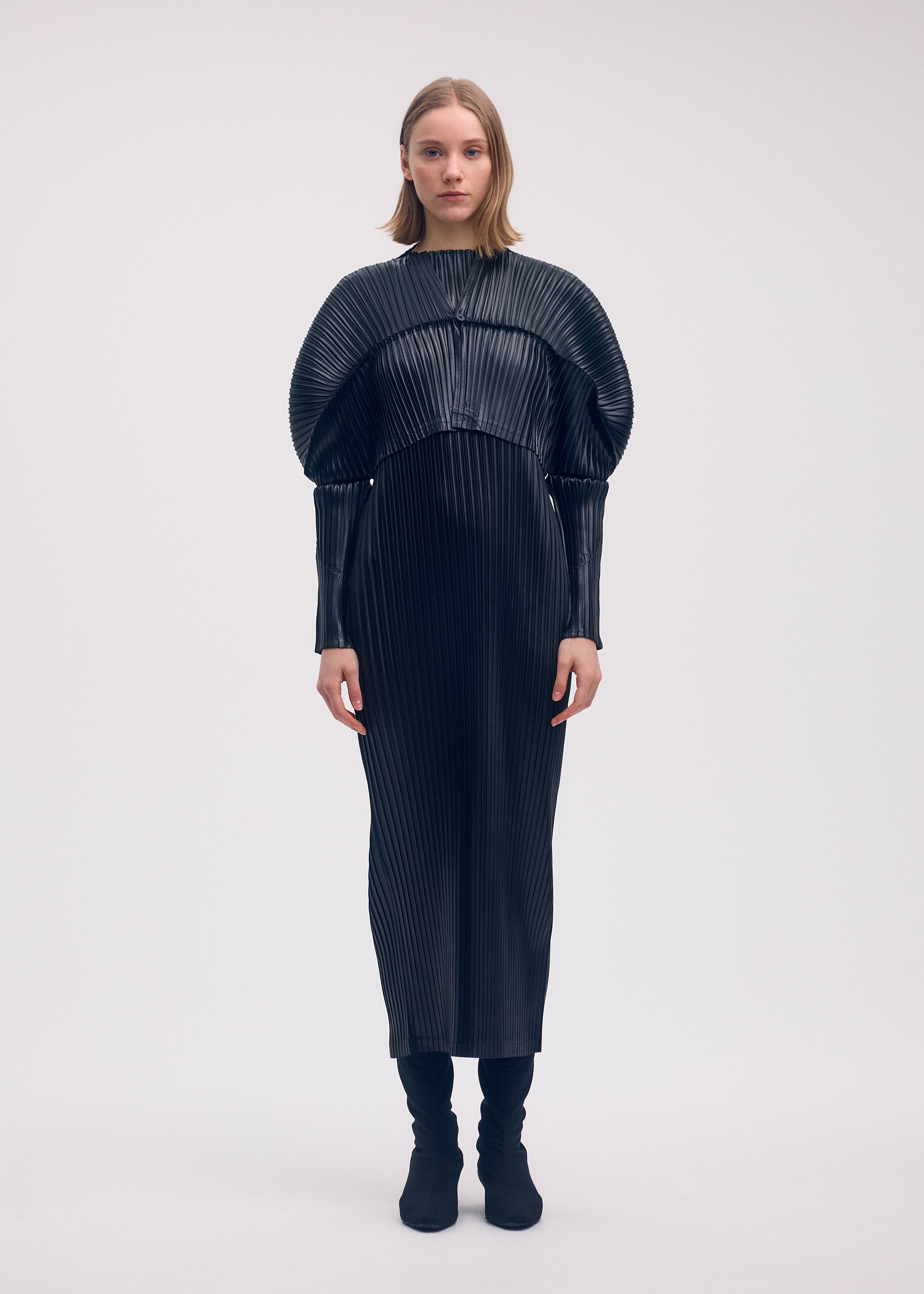 A model wears the Issey Miyake GLOSSED METAL PLEATS cardigan.